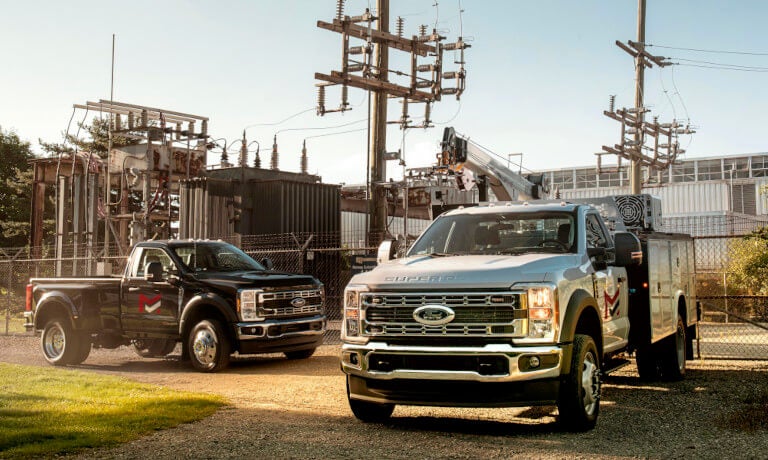 Two 2023 Ford Super Duty F-250s parked by power plant