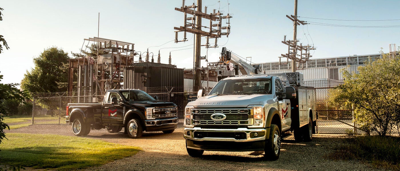 Two 2025 Ford Super Duty trucks parked outside a power plant