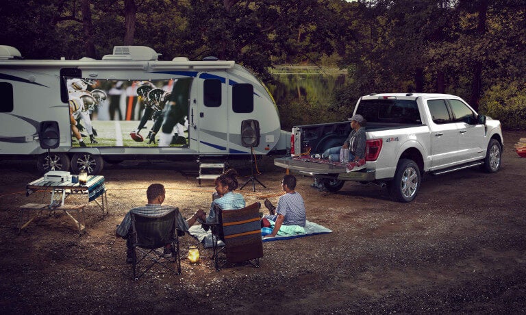 2026 Ford F-150 parked in a forest with family and RV